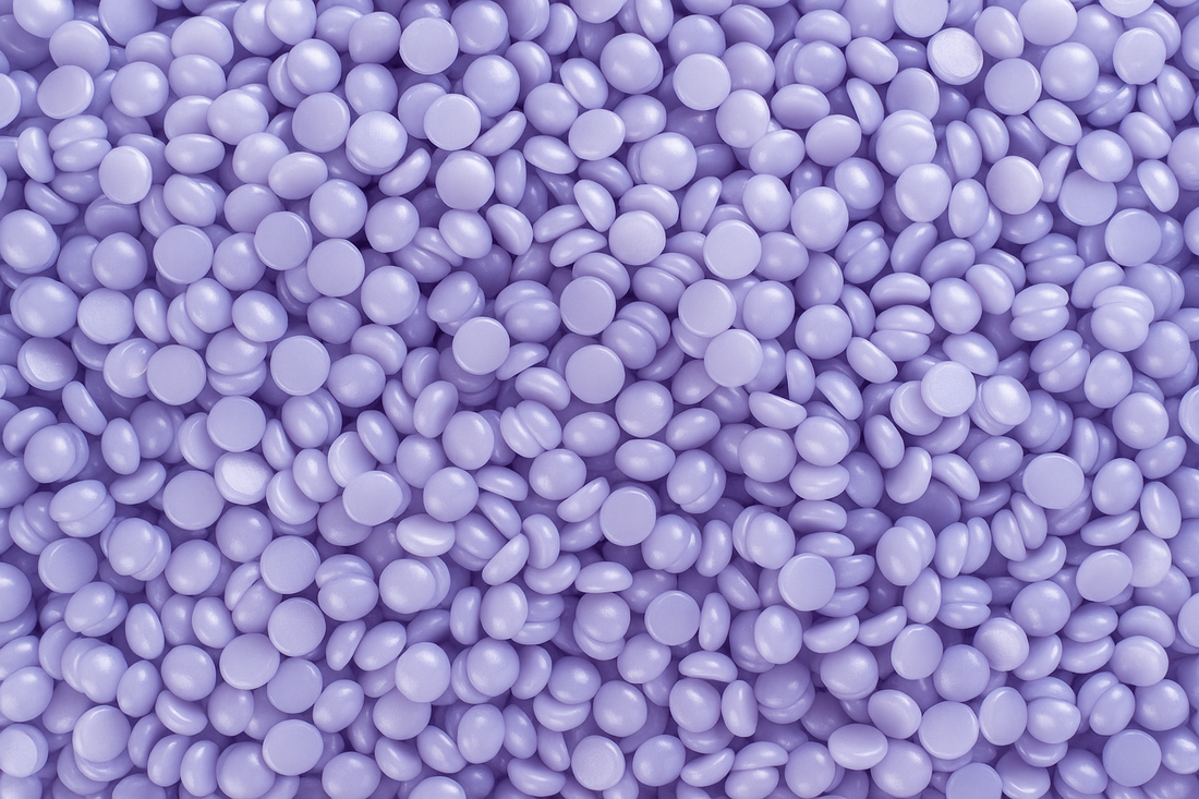 Cietā vaska granulas violetā krāsā.